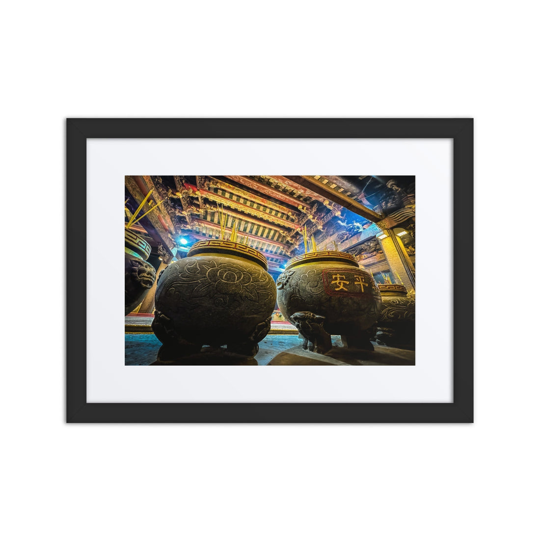 Framed photo of ornate incense burners in a vibrant, traditional Asian temple interior.